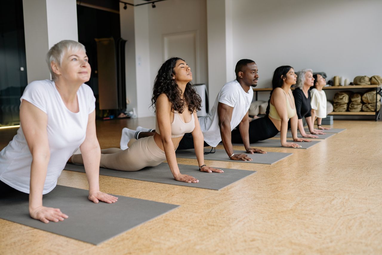 Crafting Captivating Headlines: Your awesome post title goes here A group of adults performing yoga poses on mats indoors, emphasizing diversity and wellness.